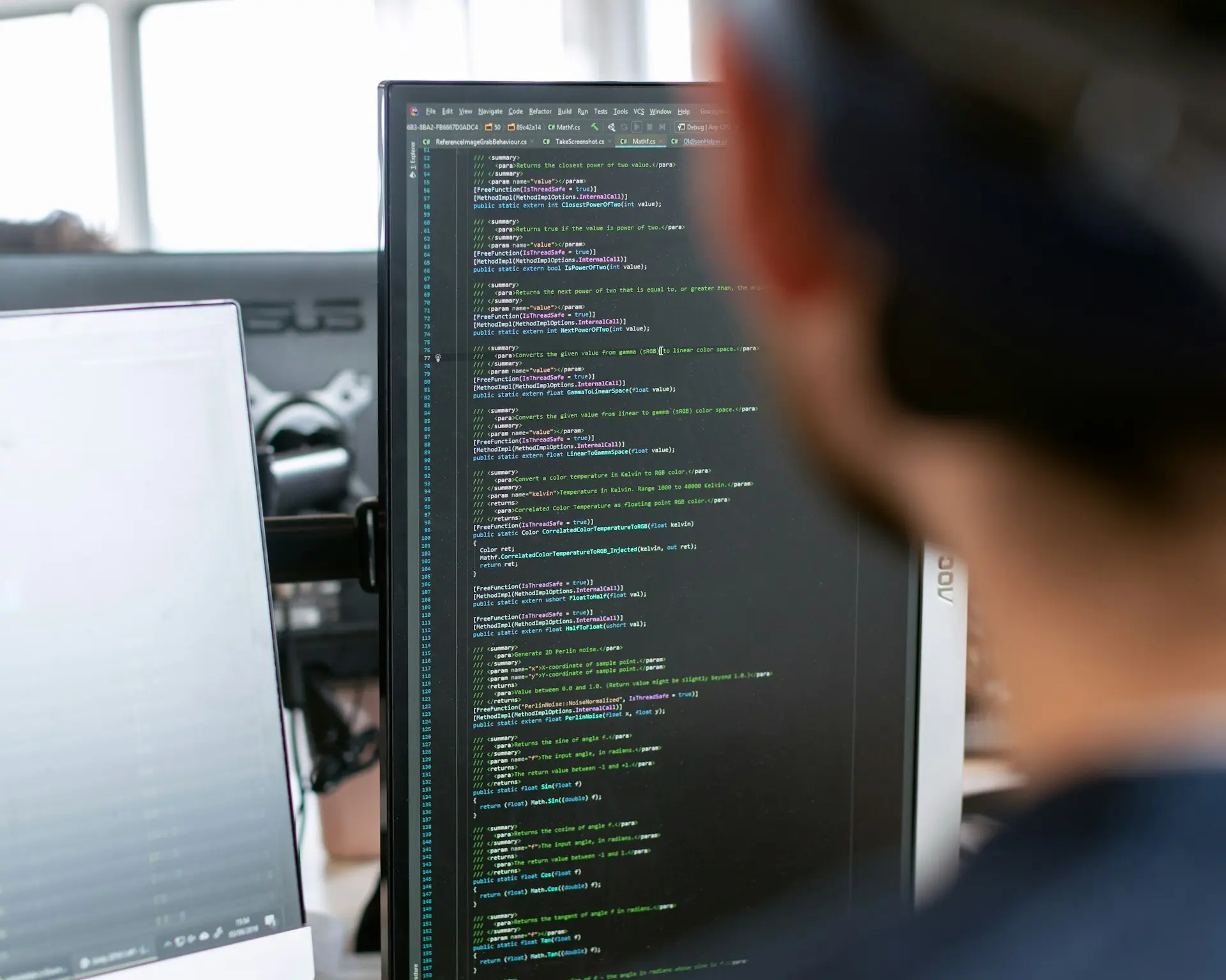 Entwickler vor einem Bildschirm mit Programmcode
