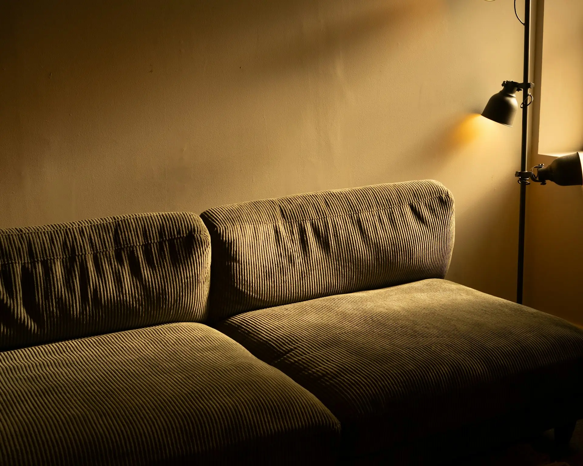 Warm beleuchtetes Sofa mit Stehlampe in der Abenddämmerung