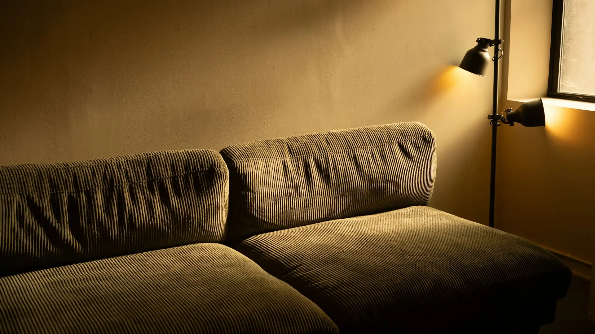 Warm beleuchtetes Sofa mit Stehlampe in der Abenddämmerung